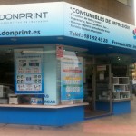 ¿Es rentable invertir en franquicias? La imagen muestra una tienda en esquina de Donprint con rótulos azules.