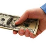 una mano con un fajo de billetes